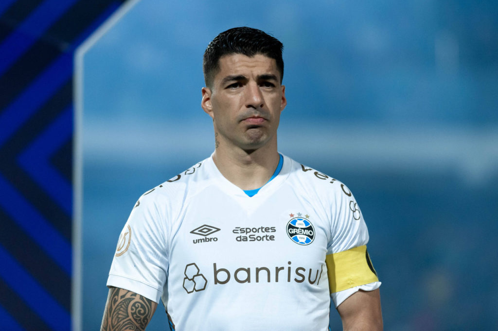 Suárez-Grêmio-Jogo-imago1032766852h Suárez, atacante do Grêmio, com a camisa do clube aguardando o início de um jogo .