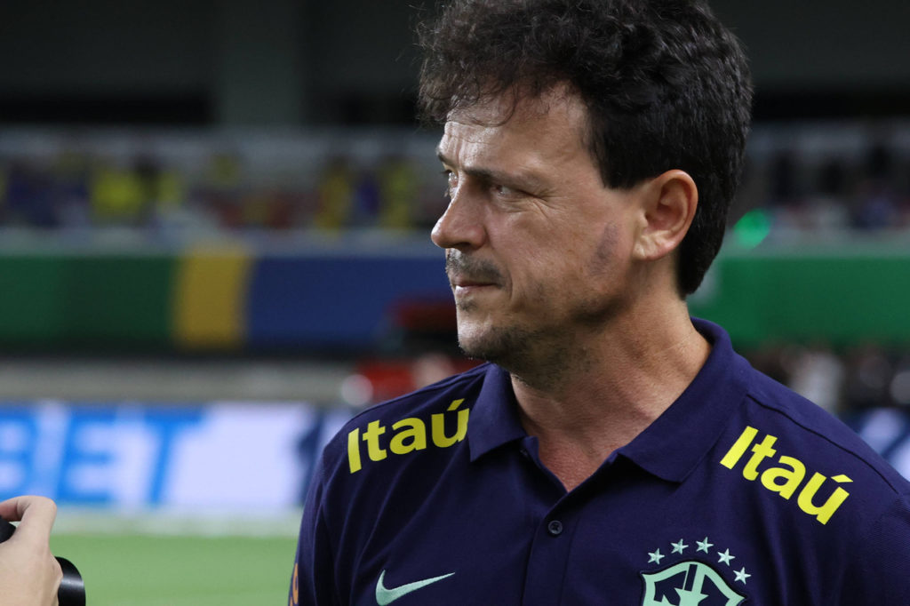 Fernando Diniz, técnico da Seleção Brasileira, vestido com o uniforme do Brasil durante um jogo da equipe.