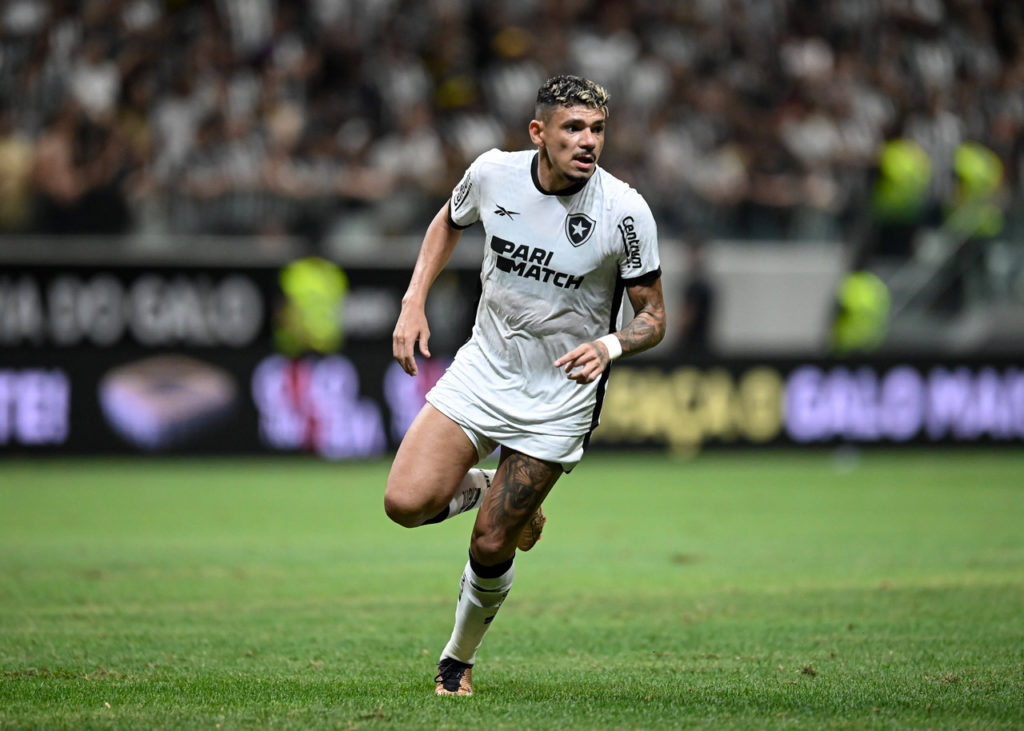 Tiquinho-Soares-Botafogo-jogo-imago1034468762h Tiquinho Soares, atacante do Botafogo, vestido com a camisa do clube e fazendo um movimento durante uma partida.
