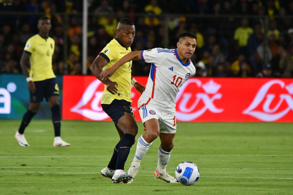 Alexis Sánchez, atacante do Chile, é marcado de perto por um jogador do Equador.