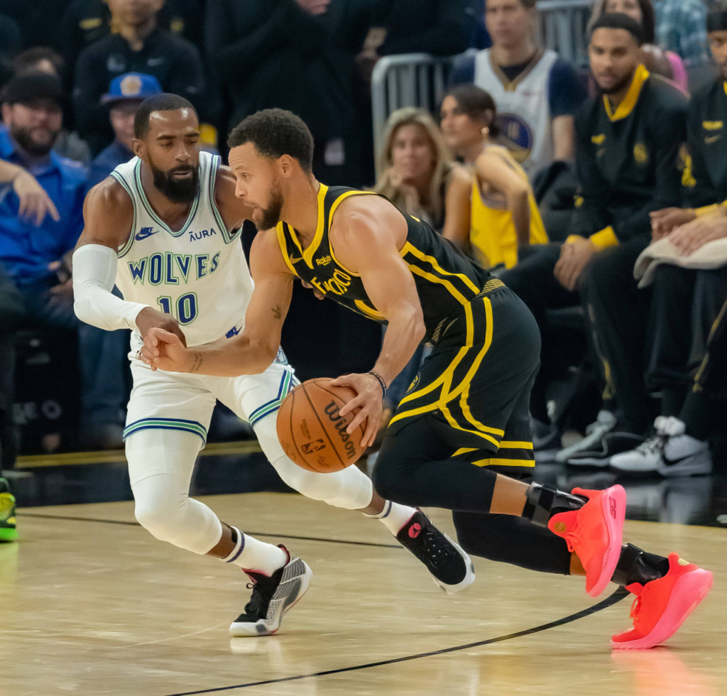 stephen-curry-atacando-imago1036932487 Stephen Curry tentando se desvencilhar da marcação de Mike Conley, do Minnesota Timberwolves no duelo do último domingo