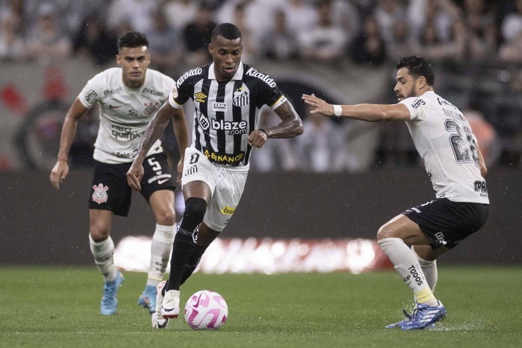 Jean Lucas, do Santos, domina a bola entre dois marcadores durante uma partida do clube.