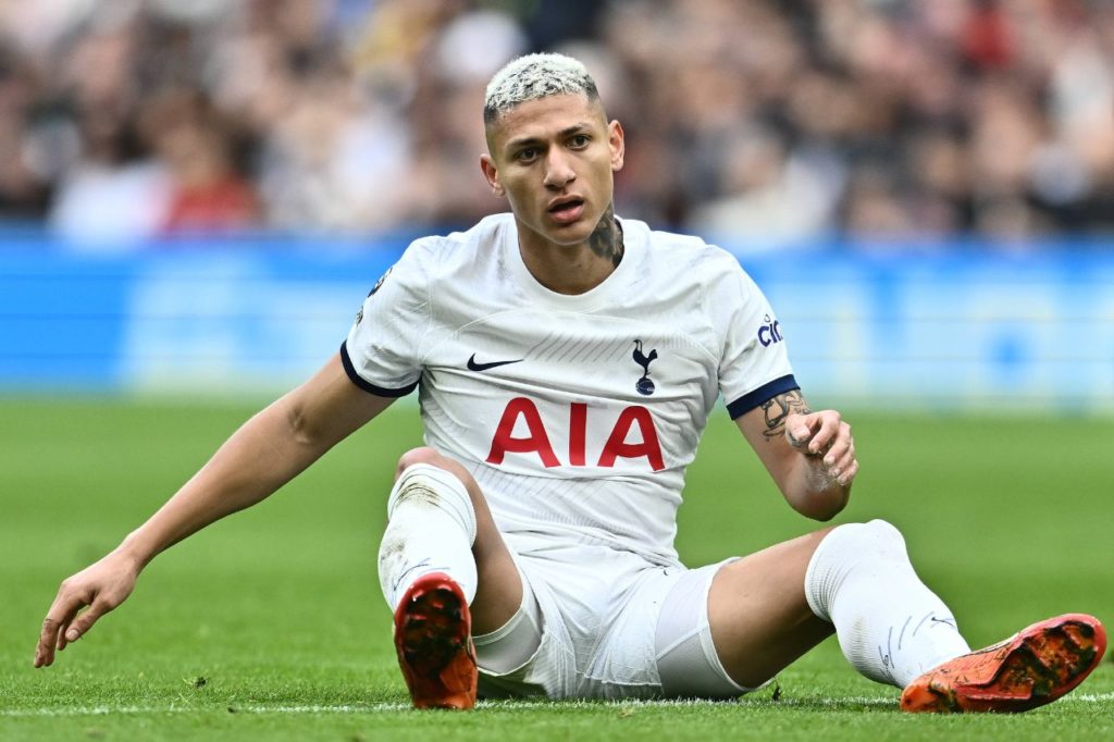 Atacante Richarlison sentado no campo em jogo do Tottenham