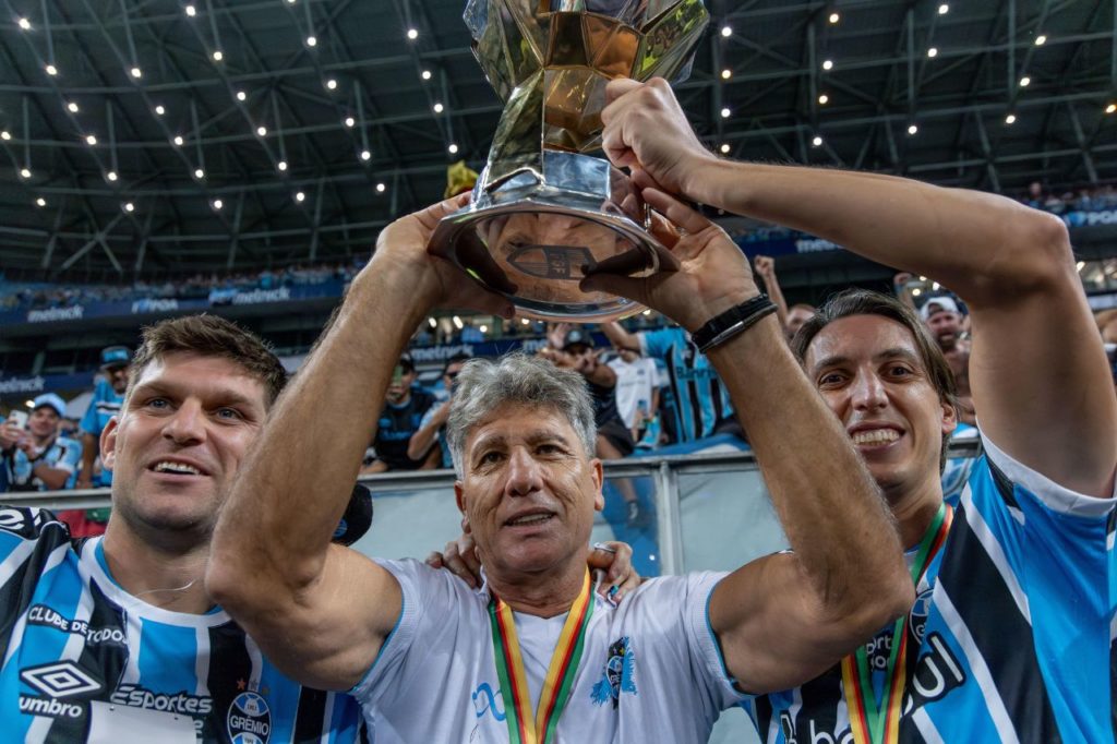 Técnico Renato ao lado de Kannemann e Geromel com a taça do Gauchão