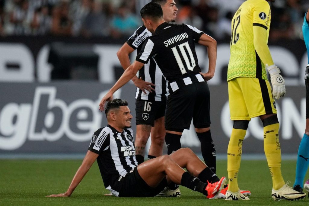 Atacante Tiquinho Soares, do Botafogo, esperando o atendimento médico no gramado do Nilton Santos