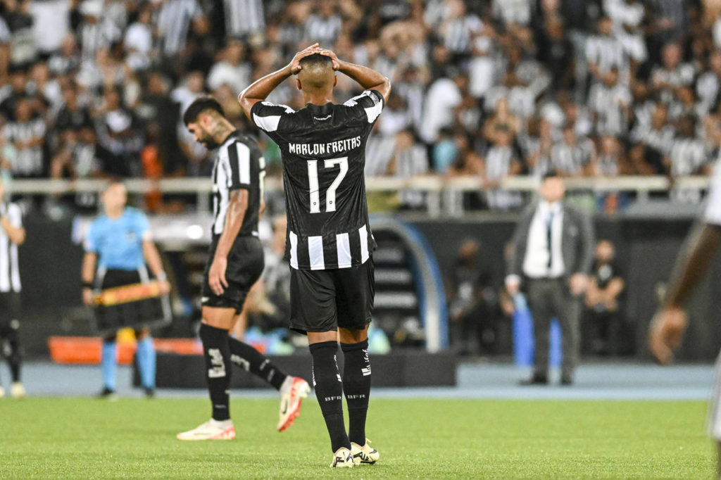 Marlon Freitas, do Botafogo, coloca as mãos na cabeça e lamenta em campo durante um jogo da Libertadores.