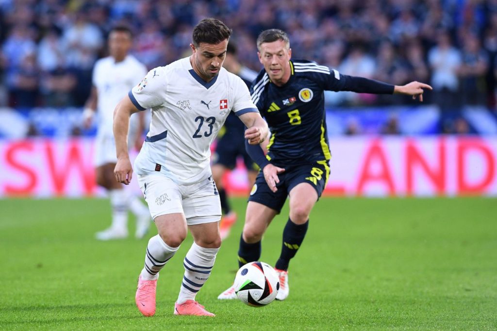 Shaqiri-McGregor-Suíça-Escócia-Euro-jogo-alamy2XD13MB Shaqiri da Suíça conduz a bola sob a marcação de McGregor da Escócia em jogo da Euro 2024